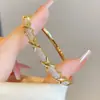 Pulseira Europeia e Americana Geométrica Banhada a Ouro em Cobre com um Toque de Luxo Leve e de Alta Qualidade, Apresentando um Design de Cruz Dourada Simples e Elegante