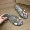 Moda Sapatinhos de Gelatina Decorados com Flores Dopamina para Mulheres Verão 2026 Novo Estilo Coreano Sandálias Planas Transparentes Doces de Cristal