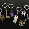 Llavero colgante de aleación de metal con diseño de mariposa Zhilang You Bean de Anime Ghost Extermination Blade que rodea el carbón. Comercio exterior.