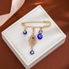Broche de borla de ojo de diablo con incrustaciones de diamantes, estilo creativo europeo y americano, con sentido avanzado, ojos azules, suéter de cintura ajustada, broche de viento frío