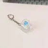 Chaveiro criativo de alta transparência com quatro botões e testador de interruptor iluminado, gadget para alívio de estresse, pingente de brinquedo transparente iluminado para presente
