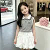 Nueva moda de verano para niñas: Conjunto de dos piezas: chaleco de cuello polo con bloques de color simple y único y falda de botón dulce y linda
