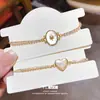 Pulsera Geométric Ovalada de Imitación de Concha con Corazón de Circonia Europea y Americana Chapada en Oro Real de 18K Joyería de Mano Elegante de Nicho de Gama Alta para Mujeres