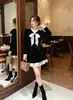 Top preto de veludo retrô estilo francês Nanyou para mulheres, decote V, com detalhe de laço, cintura marcada, mangas compridas elegantes, efeito emagrecedor, perfeito para outono e inverno