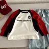 Camiseta Infantil 2026 Primavera e Outono Nova Marca da Moda para Meninos Solta Algodão Puro Bloco de Cores Carta Casual Manga Longa Tendência