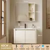 Tocador de baño engrosado y ahorrador de espacio con diseño en color crema, que cuenta con un lavabo redondeado, lavabo cerámico integrado y un lavabo de una sola pieza.