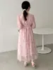 Nueva colección de verano estilo francés: un vestido ajustado, adelgazante, de longitud media en un delicado estampado floral rosa, con cintura ceñida y una superposición de malla transparente