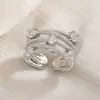 Elección artística: Anillo de junta cruzada con incrustaciones de diamantes, anillo retorcido de nicho para el trayecto diario, anillo hueco multicapa apilable de circonita