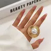 Anillo abierto de estilo dulce y fresco con personalidad de perla de imitación de metal con pliegues de viento exagerados entre Europa y Estados Unidos.
