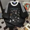 Camiseta Casual Solta Vintage de Manga Curta com Estampa Graffiti Divertida e Patchwork de Três Listras Verão 2026 Nova