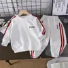 Conjunto Deportivo con Sudadera con Capucha de Dos Piezas para Niños Primavera/Otoño 2026 Conjunto de Pantalones Largos a Rayas de Bloque de Color Casual para Niños y Niñas Tendencia