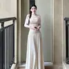 Vestido longo de manga comprida com babados, estilo novo para outono e inverno de 2026, com gola solta, caimento justo na cor damasco, perfeito para usar em camadas sob um casaco.