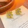Pendientes de flor de margarita incrustados de diamantes diseño nicho de lujo ligero pendientes con sentido de alta gama pendientes de moda versátiles