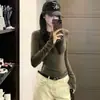 Camiseta de manga larga color verde militar estilo coreano para mujer, perfecta para principios de otoño como capa base, ofreciendo un look sofisticado y único con un corte ajustado.