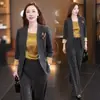 Elegante atuendo de otoño para mujer: un blazer nuevo y moderno de bloques de color, un top tipo camisola de color liso y pantalones de pierna ancha - un conjunto de tres piezas