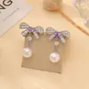 Únicos y elegantes, estos dulces pendientes de lazo con incrustaciones de diamantes y perlas exudan un aura elegante y sofisticada, ofreciendo un toque de lujo y versatilidad para cualquier atuendo.