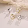 Aretes de perla en forma de trébol de cuatro hojas hueco color dorado, con un diseño floral simple y delicado, perfectos para el uso diario y para añadir un toque de dulzura y elegancia a tu look