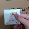 Llavero de cara sonriente de color aleación con goteo transfronterizo de comercio electrónico, accesorios de colgante para bolso con expresión irregular chapado en oro