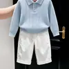 Roupas infantis coreanas coleção outono/inverno 2026: suéter de tricô azul com gola polo vazada e calça branca casual de corte reto