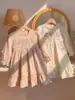 Coleção Outono 2026 Roupas Infantis Bordado Floral Francês Vestido para Meninas Gola Redonda Vestido em Camadas Manga Longa Vestido Princesa Infantil Algodão
