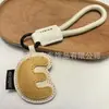 Venta al por mayor transfronteriza de llaveros japoneses y coreanos con letras en inglés, dijes para bolso de cuero dopamina, pequeños accesorios y regalos