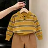 Ropa infantil estilo coreano 2026 colección otoño: suéter retro a rayas amarillas para niños y niñas, pantalones rectos color café