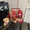 Bolsa transversal xadrez retrô para mulheres 2026 nova bolsa de mão versátil design de nicho bolsa de ombro de alta qualidade com pingente
