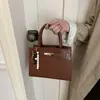 Nuevo bolso de mano para mujer 2026 con estampado de cocodrilo, moderno, de alta calidad, elegante y versátil para el trabajo, un bolso cuadrado pequeño que se puede llevar en la mano o usar como bolso de hombro o bandolera