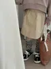 Xifan 2025 Primavera/Verão Nova Saia Curta Lisa de Algodão da Moda para Crianças Estilo Workwear para Meninas Bolso Saia Média