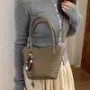 Bolso tejido de patrón único para mujer, nuevo bolso de mano de alta gama vintage otoño 2026, bolso de hombro y bandolera tipo cubo