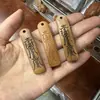 Talla de madera de durazno natural, diseño de "riqueza instantánea", disponible en varios estilos, forma rectangular con dos agujeros, adecuado para collares y llaveros DIY