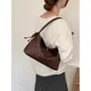 Bolso tejido de diseño de nicho de verano para mujer, nuevo modelo 2026, versátil para el trabajo, bolso de un solo hombro para llevar debajo del brazo, bolso de mano pequeño para salir