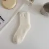 Calcetines de terciopelo de visón para mujer al por mayor otoño e invierno japoneses lindos calcetines para dormir para mujer de media pantorrilla color liso engrosados calcetines para el suelo calcetines de postparto