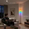 Luminária de chão estilo Bauhaus, colocada ao lado do sofá da sala de estar, exala um ambiente de quarto minimalista, sofisticado, de madeira maciça, inspirado em designs franceses.
