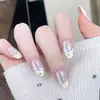 Uñas postizas prefabricadas removibles con diseño de ojo de gato y flor francesa.