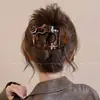 Um grampo de cabelo estiloso e versátil para mulheres, apresentando um design de bico de pato que não pressiona a parte de trás da cabeça, perfeito para criar penteados elegantes no outono e inverno.