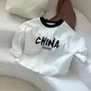 Nueva camiseta base de manga larga para niños 2026 nuevo estilo unisex color block para bebé cuello redondo camiseta top de corazón de dibujos animados primavera y otoño