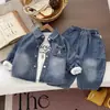 Retrô, desgastado e estiloso: um conjunto de três peças para um menino jovem com uma jaqueta jeans lavada e degradê combinada com calça jeans