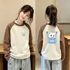 Camiseta de manga larga para niña, moderna y elegante, con bloques de color, cuello redondo y estampado de dibujos animados, perfecta como capa interior para otoño e invierno 2026