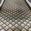 Pantalla geométrica de acero inoxidable con diseño calado, utilizada como mampara en vestíbulos de hoteles y oficinas de ventas, ofreciendo una estética de lujo ligero.; pantalla metálica hecha a medida para proyectos arquitectónicos