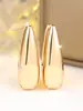 Aretes de gota de agua de superficie lisa dorada de alta gama con temperamento transfronterizo, estilo minimalista para el commute