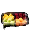 Caja rectangular de plástico transparente con tapa, compartimentada y sellada, para empaquetar ensalada de frutas.