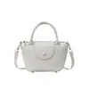 El popular bolso tipo cubo de estilo fresco de este año para mujer es el nuevo modelo de verano 2026, un bolso de hombro de color liso con textura adecuado para ir al trabajo y para llevar cruzado.
