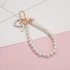 Venta al por mayor de llaveros creativos de perla de amor, estilo retro coreano, con concha y perla, para bolso, colgante para auriculares, accesorios para colgar.