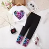 Conjunto de Verano para Niñas: Camiseta Blanca de Manga Corta con Estampado de Corazones, Pantalones Negros Largos con Puños de Estampado de Leopardo Multicolor