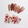 Unhas postiças em formato de coração vermelho-acastanhado, unhas trapezoidais longas com coração bordô e glitter floral, disponíveis para atacado
