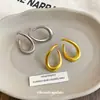 Pendientes de anillo retorcido minimalistas europeos y americanos de aguja plateada, pendientes de lujo ligero de alta gama, pendientes de diseño único de nicho al por mayor
