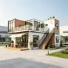 Casa comercial modular de múltiples cajas con empalme escalonado, plataforma de madera al aire libre para ocio, tienda de té y postres en zona escénica