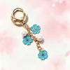 Colgante de llavero de aleación de doble flor más vendido transfronterizo, con lindos accesorios de flor de cerezo y perlas, adecuado para fundas de auriculares y bolsos