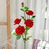 Rosa roja artificial con tallos largos, presentando cinco rosas grandes y vibrantes de terciopelo rojo. Ideal para decoración del hogar, fotografía y arreglos de boda